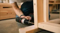 Thomas monteert een houten meubel met een boormachine